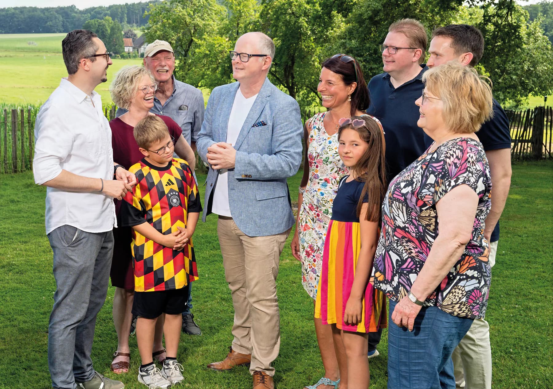 Thomas Spieker im Gespräch mit einer Familie im Garten