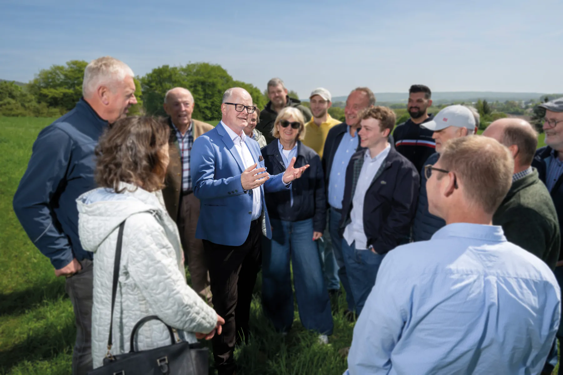 Thomas Spieker im Gespräch mit einer Gruppe von Menschen auf einer Wiese in Bad Iburg