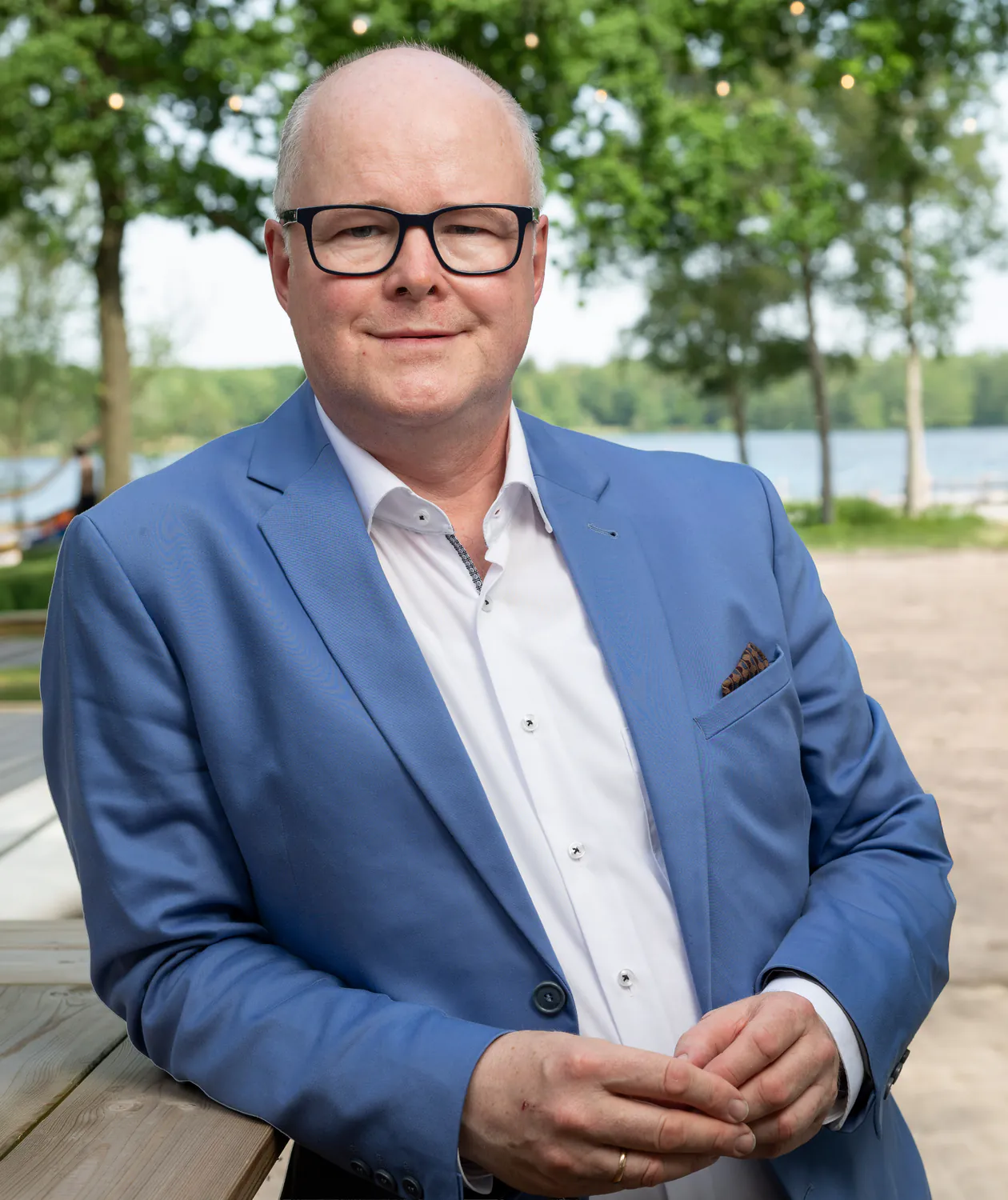 Thomas Spieker im blauen Sakko an einem See, halbnah
